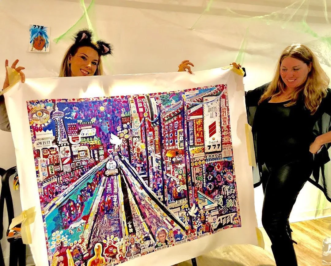 Two women smiling while displaying a large print of The Day of Transcendence