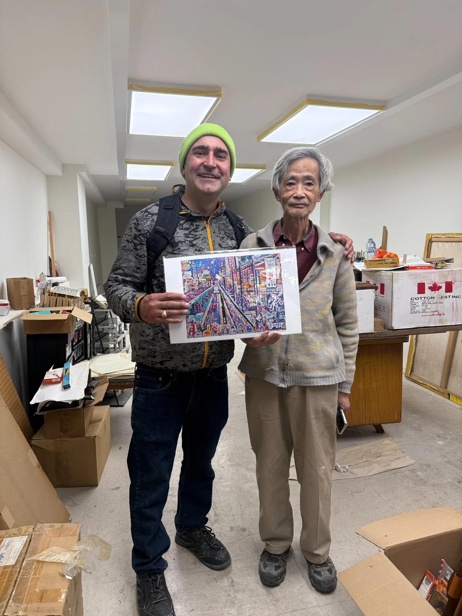 STEEP Daniels, left, and Daniel Chi of Daniel’s Art Supplies, right, holding STEEP’s Chinatown painting The Day of Transcendence